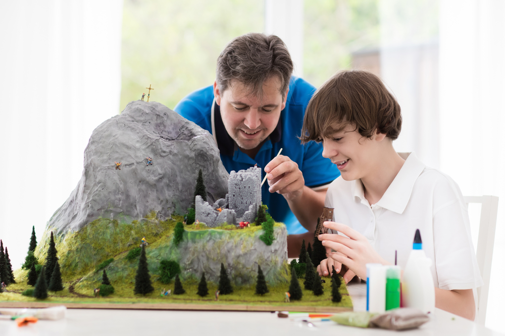 father and Son Paint on Model Train